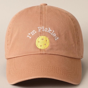 K&ouml;nnte beinhalten: Eine braune Baseballkappe mit dem Text "I'm Pickled" in wei&szlig; gestickt und einem gelben Pickleball-Motiv.