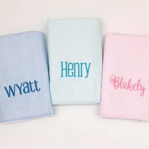 May include: Three personalized baby blankets, one light blue with the name Wyatt, one light blue with the name Henry, and one pink with the name Blakely.