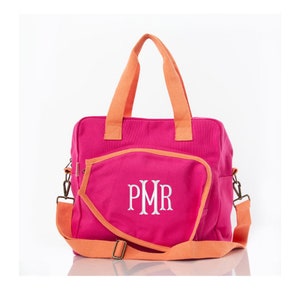 May include: A pink canvas tote bag with orange handles and trim. The bag has a large pocket on the front with the monogram "PMR" embroidered in white.
