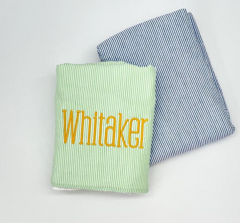 May include: Two striped fabric towels, one green and one blue, with the name "Whitaker" embroidered in yellow on the green towel.