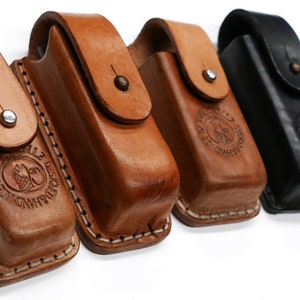 Op de afbeelding: Vijf leren etuis voor kleine gereedschappen of zakmessen. De etuis zijn in twee kleuren: bruin en zwart. Elk etui heeft een gestikte rand en een kleine metalen knop. De etuis hebben een gegraveerd logo aan de voorkant.