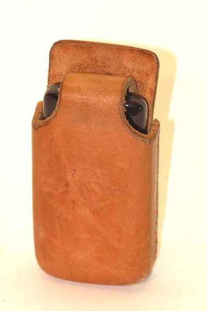 May include: A brown leather case for a cell phone or other small electronic device.