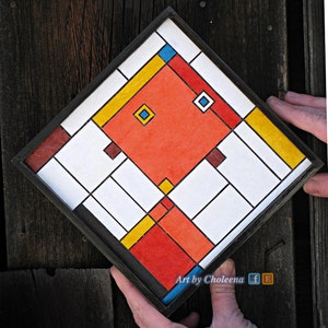 May include: A framed geometric abstract art piece with a black frame. The artwork features a red, yellow, blue, and white color scheme. The artwork is titled "Art by Choleena".
