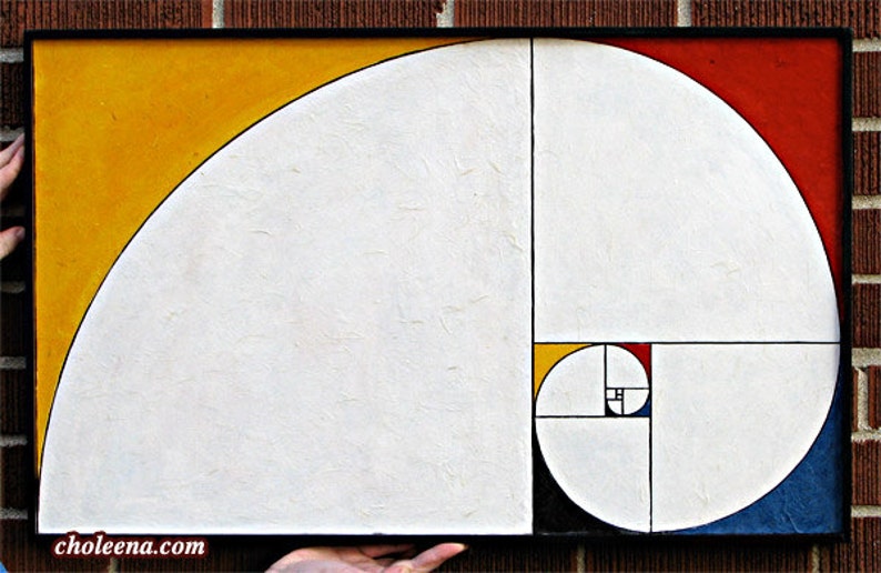 May include: Abstract painting featuring a Fibonacci sequence spiral in white, yellow, red, and blue. The artwork is framed in black and held against a brick wall. The painting has a textured surface.
