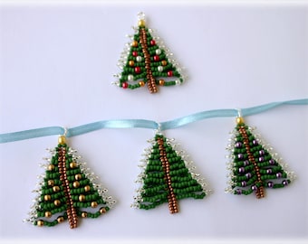 May include: Four beaded Christmas tree ornaments, three hanging from a blue ribbon and one on its own. The trees are green with silver and gold beads, and one has purple beads.