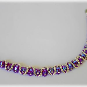 Könnte beinhalten: Ein violettes und silbernes Armband mit einem Spiralmuster.