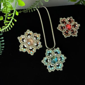 Può includere: Tre ciondoli a forma di fiore perlato, uno su una catena d'argento. I fiori sono realizzati con perline iridescenti e hanno una pietra centrale. Le pietre sono di colore pesca, rosso e blu.