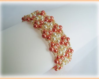 Puede incluir: Un brazalete de cuentas con un patrón tejido en tonos coral, blanco y dorado.