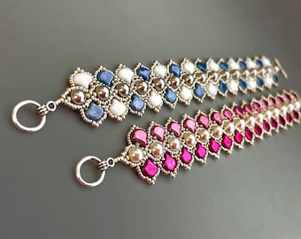 May include: Two beaded bracelets with silver accents. One bracelet features blue, white, and silver beads, while the other features pink, white, and silver beads.