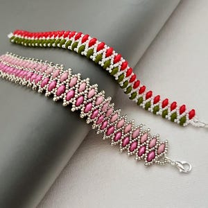 May include: Two beaded bracelets. One is pink and silver, with a repeating pattern of pink beads. The other is red, white, and green, with a zig-zag pattern. Both have silver clasps.