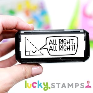 May include: A black and white self-inking stamp with a speech bubble that says "All Right, All Right!" and a small right triangle with a dotted line.