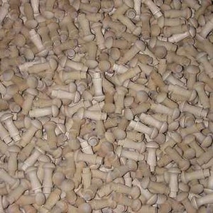 May include: A large pile of small, off-white wooden knobs. The knobs are all the same size and shape, and they are arranged in a random pattern.