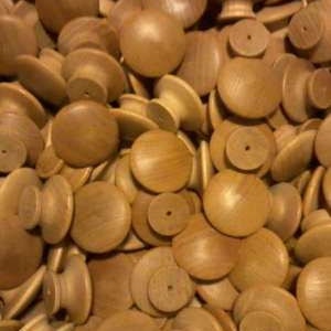 May include: A pile of wooden knobs in a light brown color. The knobs are round with a small hole in the center. They are perfect for adding a rustic touch to furniture.