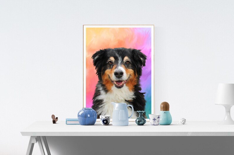 May include: A framed painting of a dog with black, brown, and white fur. The dog is smiling and has a colorful background behind it. The painting is on a white table with a variety of blue and white ceramic items.