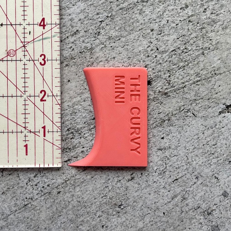 May include: A pink plastic tool called "The Curvy Mini" for crafting and creating curves in clay or polymer clay.