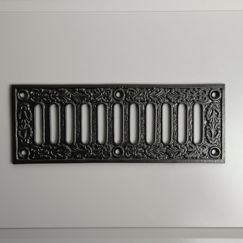 May include: Black cast iron vent cover with a decorative floral design and 10 rectangular openings.