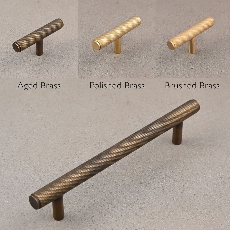 May include: Three cabinet knobs in different finishes: aged brass, polished brass, and brushed brass. Each knob has a textured, cylindrical design with a T-shaped base.