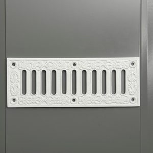 May include: White cast iron vent cover with a decorative floral design and 10 rectangular openings.