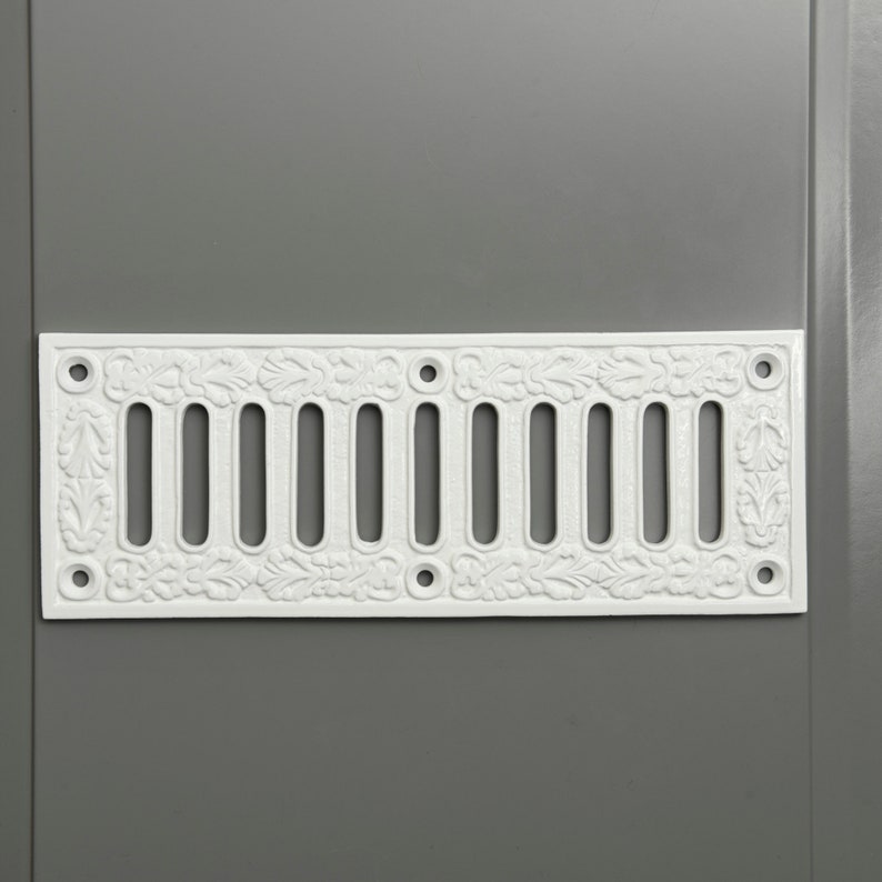 May include: White cast iron vent cover with a decorative floral design and 10 rectangular openings.