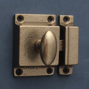 Pode incluir: Um fecho de metal prateado com uma pega oval. O fecho tem um acabamento texturizado e é projetado para uso em portas ou armários.