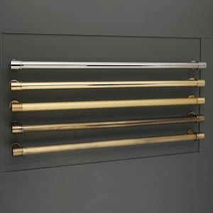 Puede incluir: Cuatro tiradores de armario de metal en varios acabados: cromo pulido, latón pulido, latón antiguo y latón satinado. Los tiradores son todos del mismo tamaño y forma, con un diseño cilíndrico.