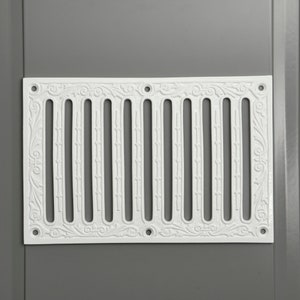 May include: White decorative vent cover with a floral design and a series of vertical slots.