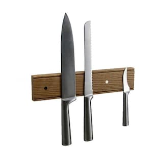 May include: A wooden magnetic knife holder with three knives attached. The holder is brown with a light wood grain. The knives are silver and have different blade shapes.