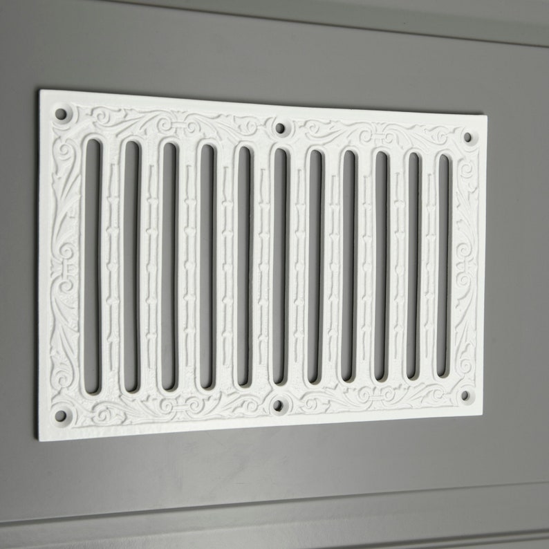 May include: White cast iron vent cover with a decorative floral design and a series of vertical slots.