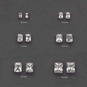 May include: Assortment of clear, rectangular, faceted gemstones in various sizes. The gemstones are arranged in rows, with each row labeled with the dimensions of the stones in millimeters. The sizes are 5x3 mm, 6x4 mm, 7x5 mm, 8x6 mm, 9x7 mm, and 10x8 mm.