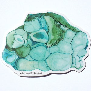 May include: Abstract watercolor painting of a green and blue stone with a white background. The painting has a unique, organic shape and a textured surface. The artist's website, AdrienneVita.com, is printed in the bottom right corner.