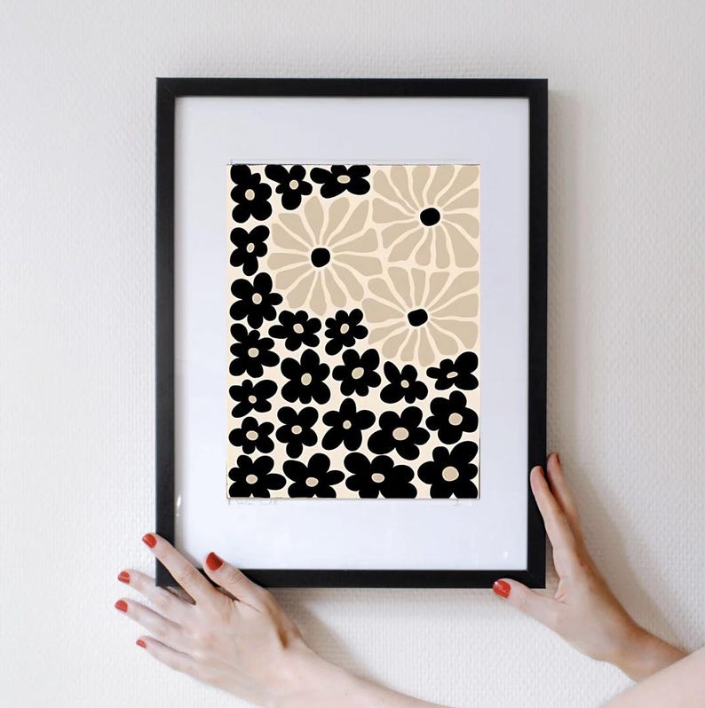 May include: A framed print with a black and beige floral pattern. The print features a repeating pattern of black flowers on a beige background.