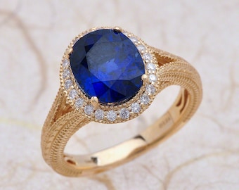 Op de afbeelding: Een gouden ring met een grote ovale blauwe saffier omringd door een halo van kleinere diamanten.