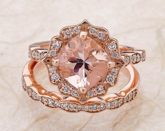 May include: A rose gold engagement ring set with a cushion-cut morganite center stone and a halo of smaller diamonds. The band is also set with diamonds and has a scalloped edge.