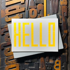 A card to just say HELLO and send to family and your friends.  
Made from a grid of square wooden type blocks. Printed using fluorescent yellow ink with a deep impression print. Luxurious Colorplan Pristine White thick 350gsm double-sided card.