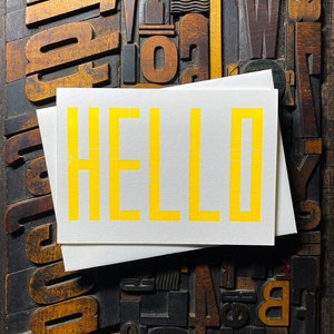 A card to just say HELLO and send to family and your friends.  
Made from a grid of square wooden type blocks. Printed using fluorescent yellow ink with a deep impression print. Luxurious Colorplan Pristine White thick 350gsm double-sided card.