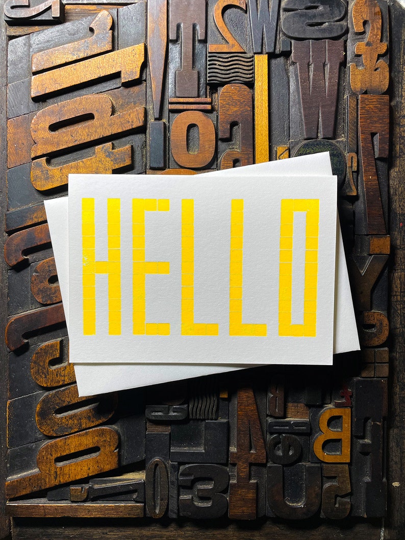 A card to just say HELLO and send to family and your friends.  
Made from a grid of square wooden type blocks. Printed using fluorescent yellow ink with a deep impression print. Luxurious Colorplan Pristine White thick 350gsm double-sided card.