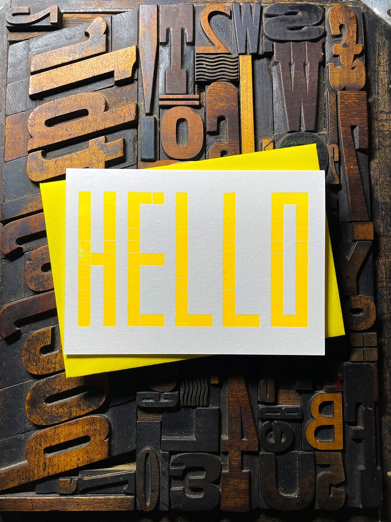 A card to just say HELLO and send to family and your friends.  
Made from a grid of square wooden type blocks. Printed using fluorescent yellow ink with a deep impression print. Luxurious Colorplan Pristine White thick 350gsm double-sided card.