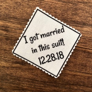 May include: White fabric square with black text that reads "I got married in this suit! 12.28.18".