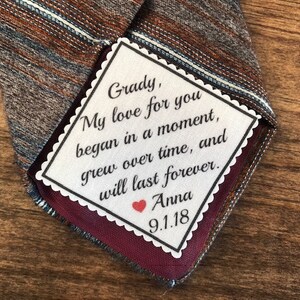 May include: A white tag with scalloped edges and a handwritten message that reads "Grady, My love for you began in a moment, grew over time, and will last forever. Anna 9.1.18". A red heart is drawn next to the name Anna.