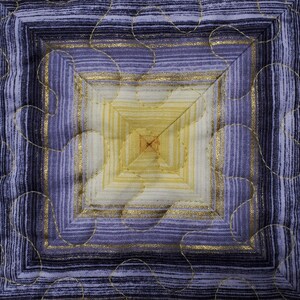 May include: A square quilted fabric with a concentric pattern of gold and purple stripes. The center of the square is a lighter shade of yellow.