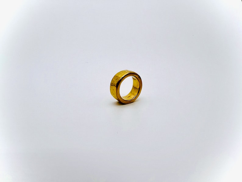 May include: A gold-colored ring with a textured surface.