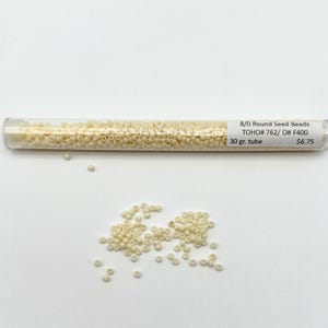 May include: A tube of 8/0 round seed beads in a cream color. The tube is labeled "8/0 Round Seed Beads TOHO# 762/O# F400 30 gr. tube $6.75".