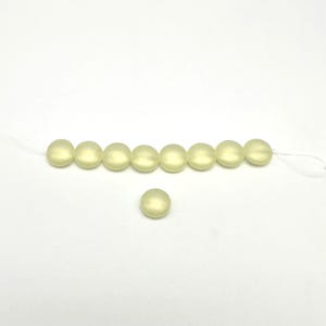 May include: A strand of eight pale yellow round beads with a single bead of the same color and size below it.