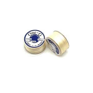 May include: Two spools of white nylon thread, each with a blue and white label that reads "One G Made in Japan 330dtex NYLON 100% 50 yards (approx. 46m) 発売元:トーホー株式会社"