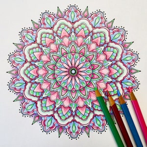 May include: A detailed mandala design with intricate patterns in shades of pink, blue, and green. The mandala is surrounded by a border of small dots.