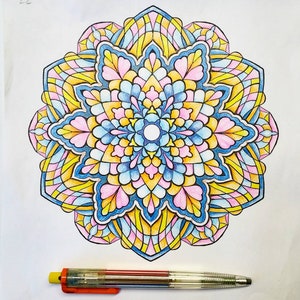 May include: A colorful mandala design with intricate details in shades of pink, blue, yellow, and white. The mandala is drawn in a circular pattern with a central point and radiating lines.