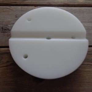 May include: White plastic circle with three holes and a split down the middle.