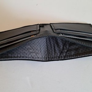 Schwarze Ledergeldbörse mit 4 Kartenfächern und innen gefüttertem Innenraum für Bargeld. Weich. Schlank. Handgefertigt. Minimal. Einzigartig.