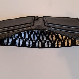Schwarze Ledergeldbörse mit 4 Kartenfächern und innen gefüttertem Innenraum für Bargeld. Weich. Schlank. Handgefertigt. Minimal. Einzigartig.