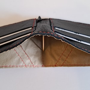 Schwarze Ledergeldbörse mit 4 Kartenfächern und innen gefüttertem Innenraum für Bargeld. Weich. Schlank. Handgefertigt. Minimal. Einzigartig.